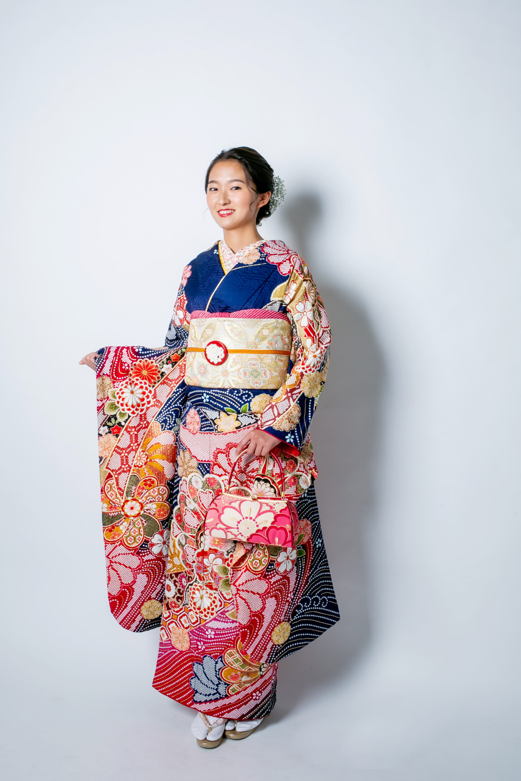 赤と紺を基調にした総絞り・辻が花振袖。華やかな花柄と伝統技法が際立つ成人式向け振袖コーディネートの全身写真。